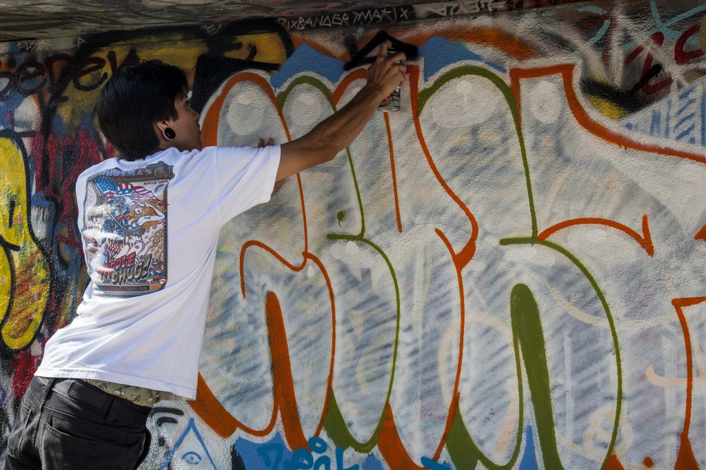 Graffiti artist, Carlos Mercado, 20, puts some finishing touches on his wall. Mercado is currently looking for employment in Inglewood. Photo: Lynn Levitt