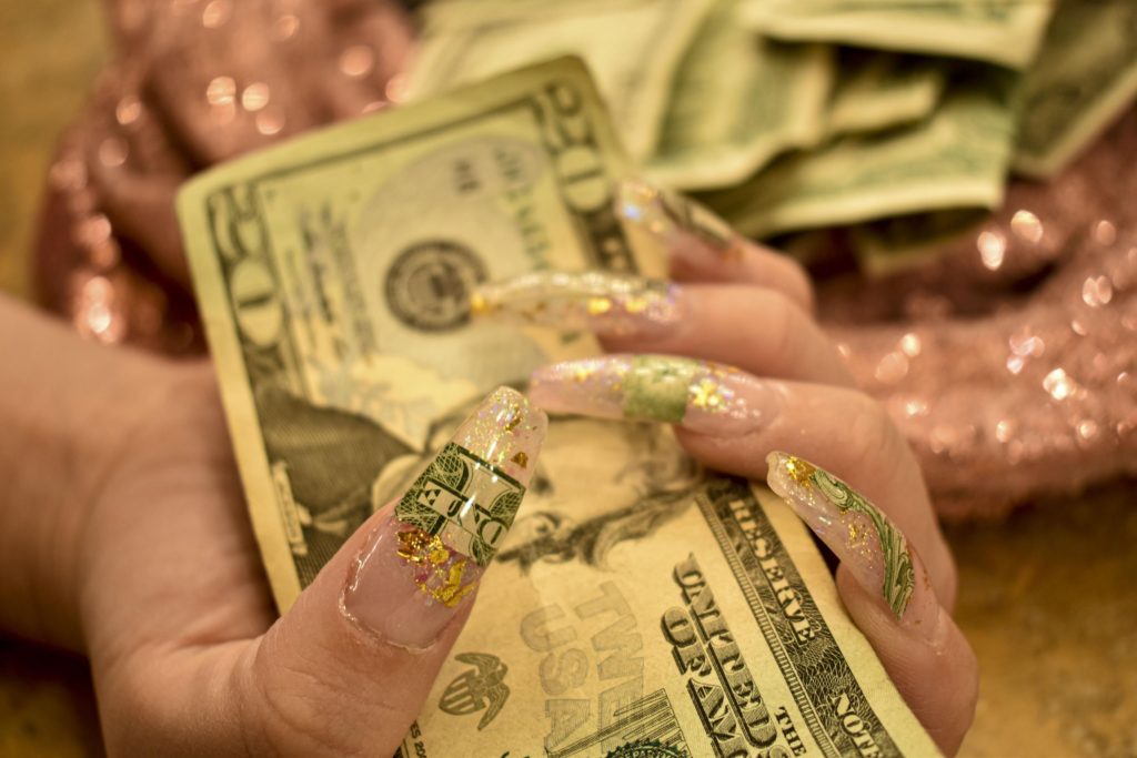 Several dollar bills rest in Dylan’s hand back stage at the Odd Ball Cabaret.
