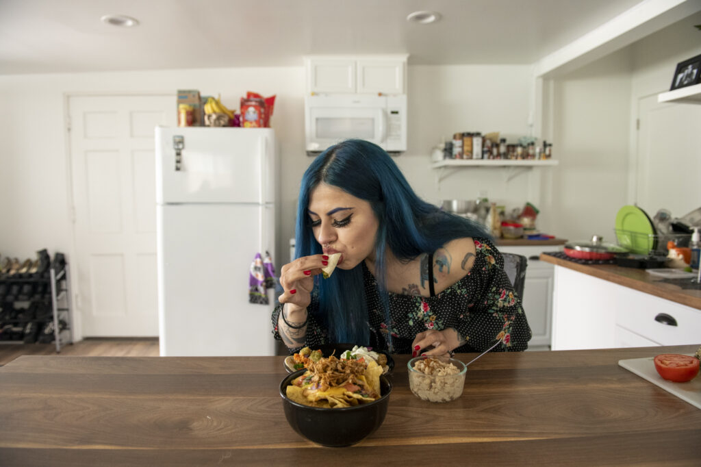 Araceli Guerrero takes a bite of Louis Fuentes’ vegan fish tacos in Cypress, Calif., on March 14, 2021. Photo by Jackelyn Ruby.